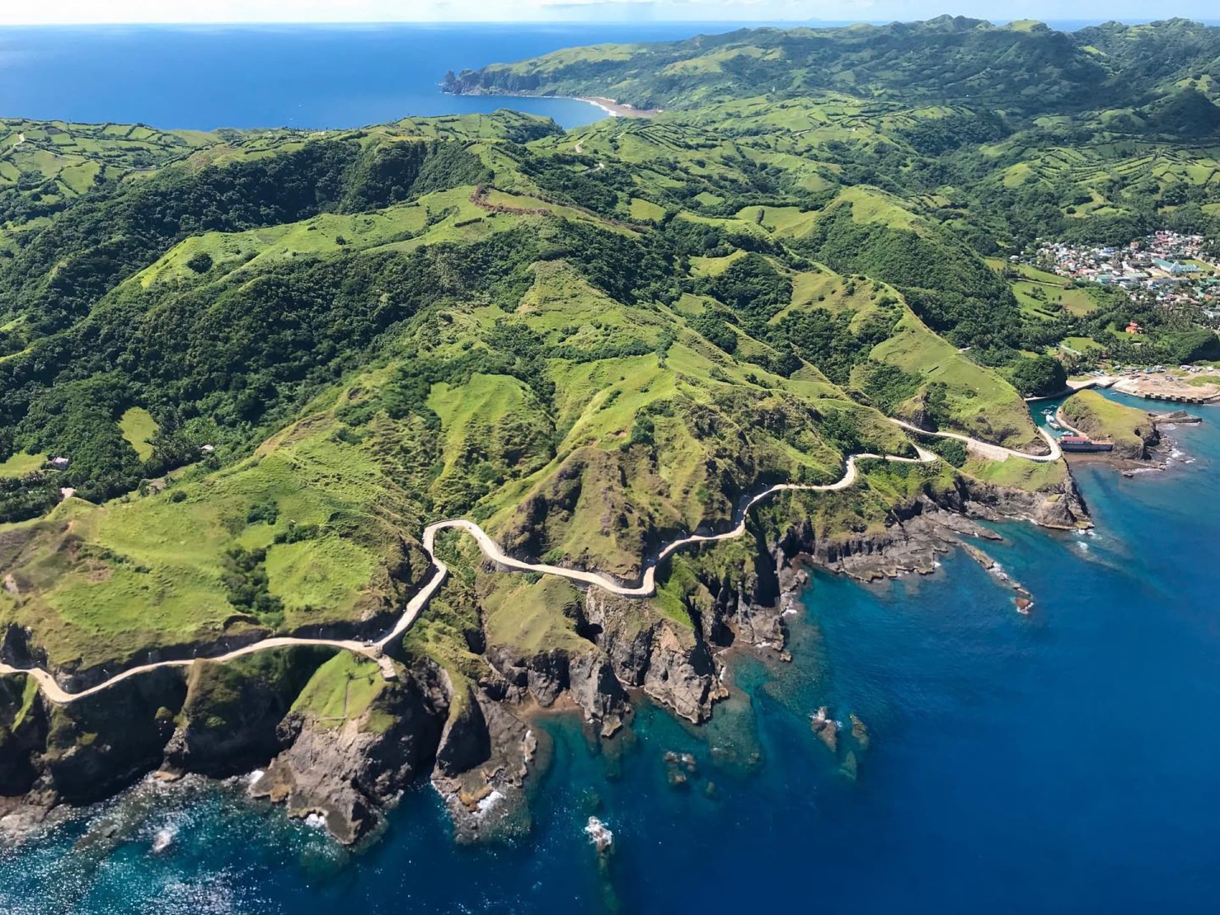 Aerial view of Batanes green coastal cliffs and blue sea
